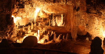 Wide angle image of an interior cavern illuminated by lights.