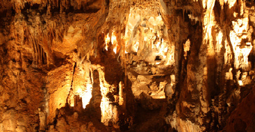 Interior of a cavern with lights illuminating it.