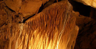 Interior of a cavern wall illuminated by light.