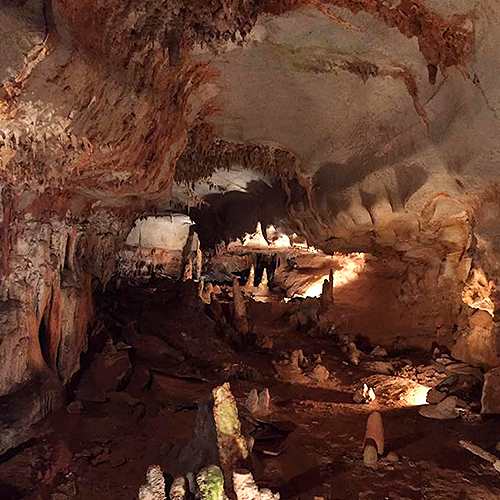 Interior of a deep cavern with lights illuminating it.