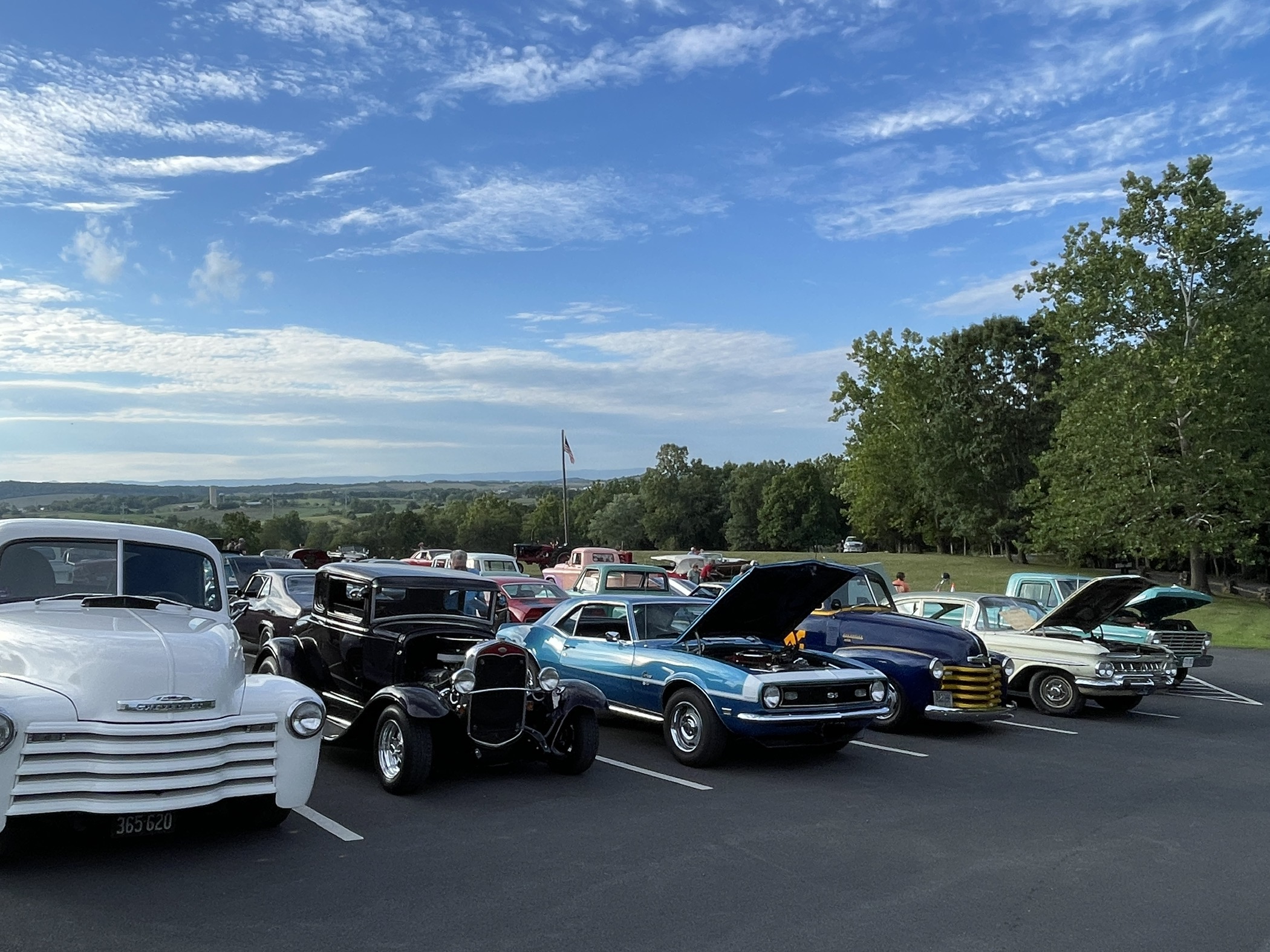 Classic cars lined up with hoods open at Endless Caverns Car Show