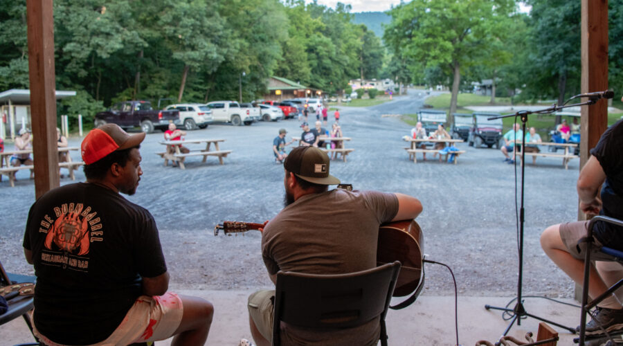 Guitar Player playing music with guests gathered around