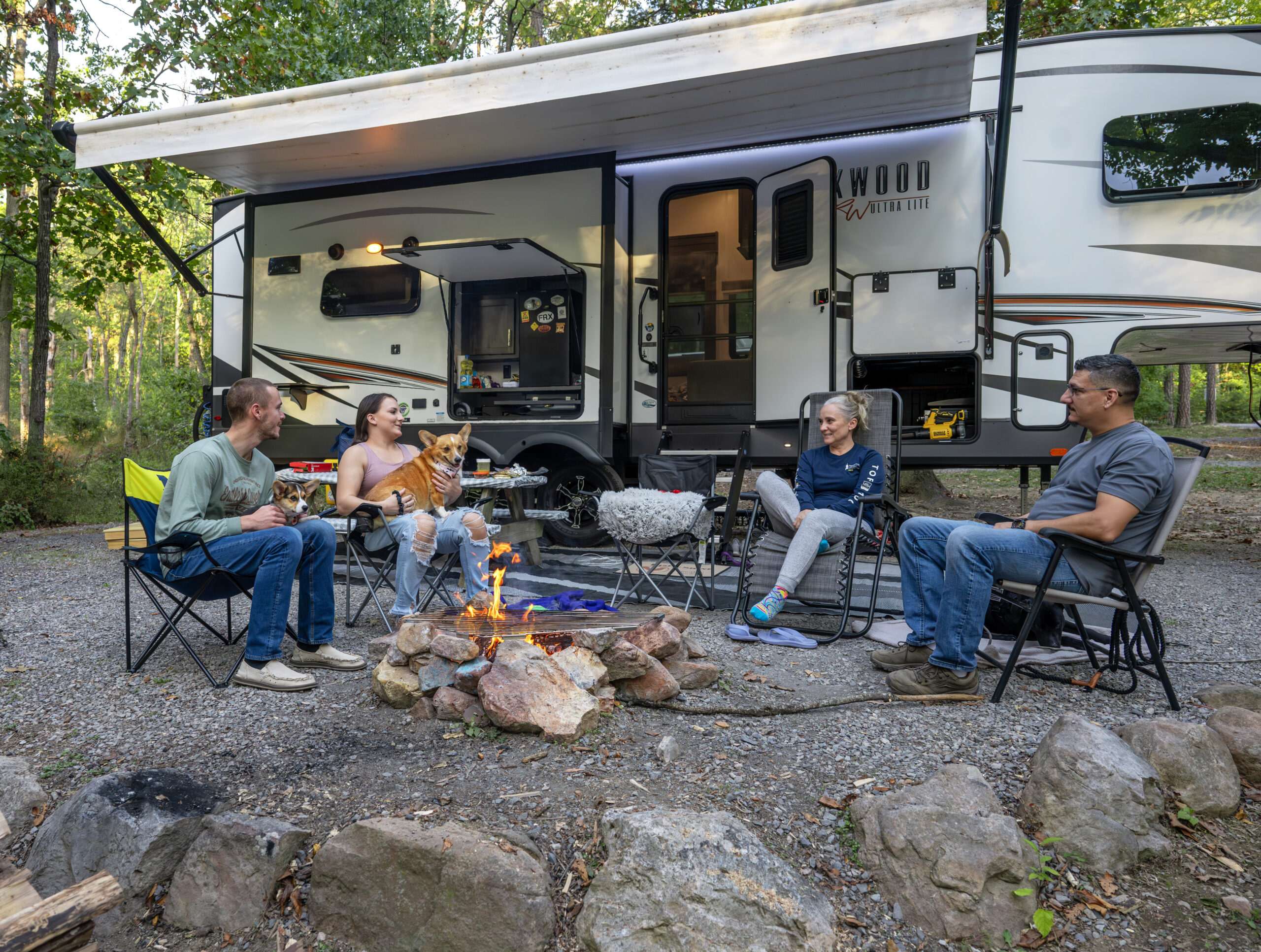 Family gathered around an RV Site with RV in the background