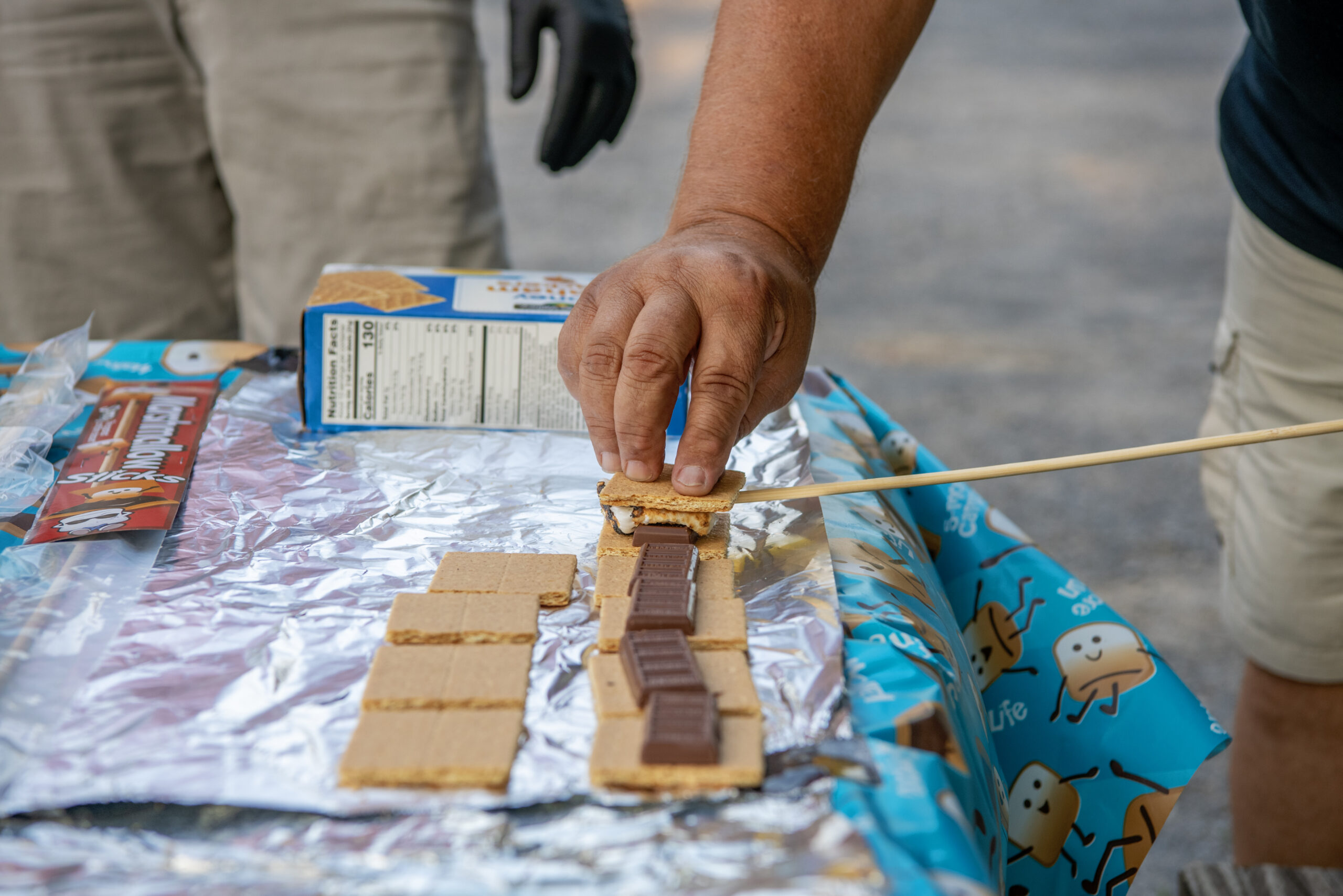 A person making smores with graham crackers