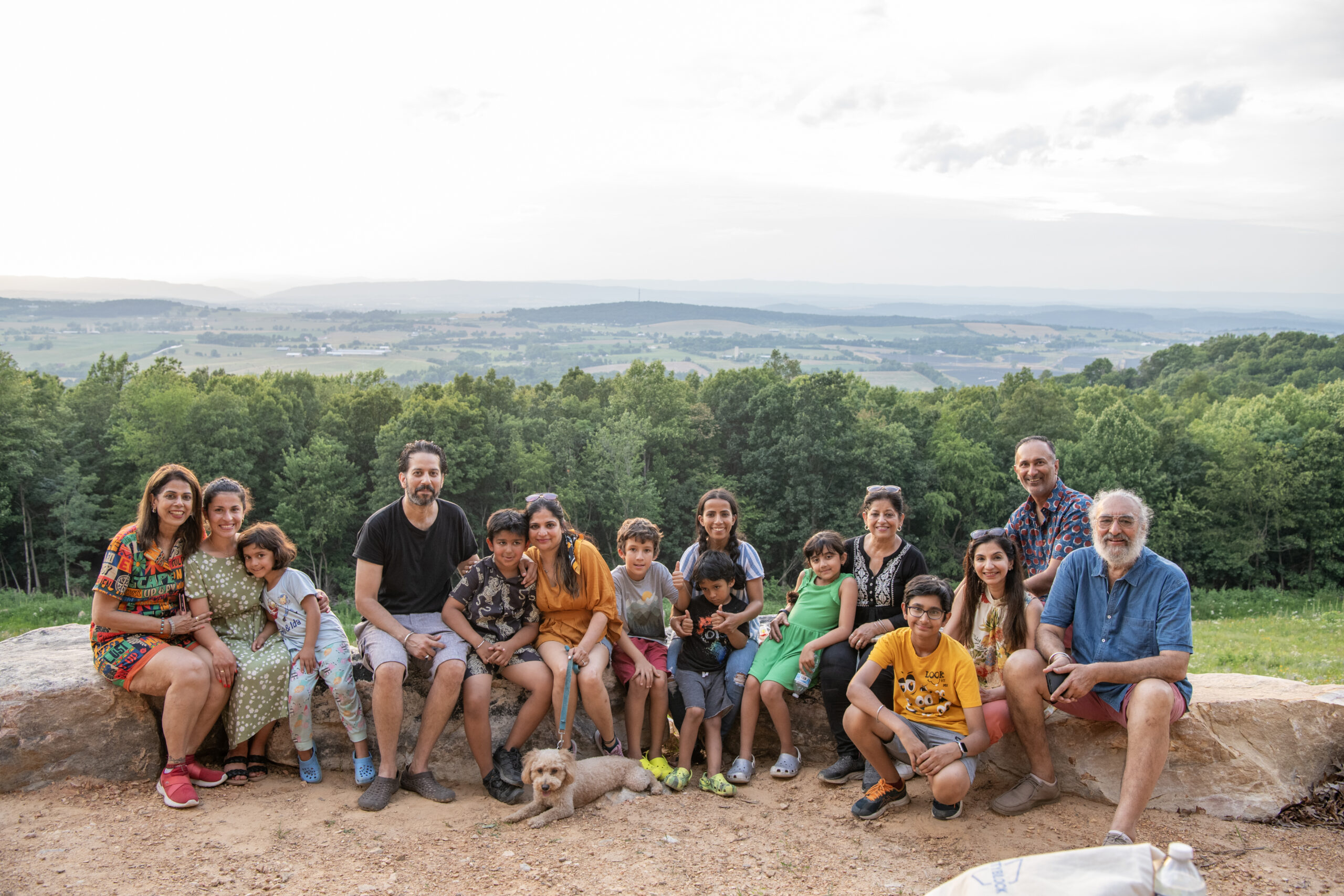 Large family sitting at the top of the mountain with view of Shenandoah Valley behind.